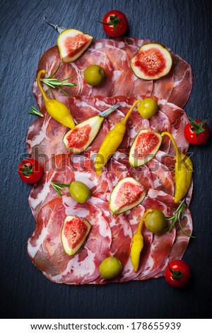 Meat catering platter with olives, hot peppers and figs