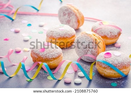 Traditional Berliner for carnival and party. German Krapfen or donuts with streamers and confetti. Colorful carnival or birthday image Foto stock © 
