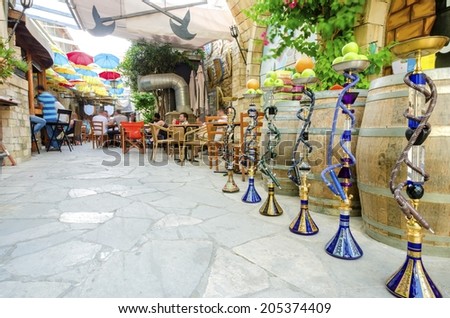 LIMASSOL, CYPRUS - 30 MAY 2014: Stoa Fylaktou in the historic medieval city center of Limassol in Cyprus. A view of the cafe, restaurant, the colorful umbrellas hang over the tables, a line of shisha.