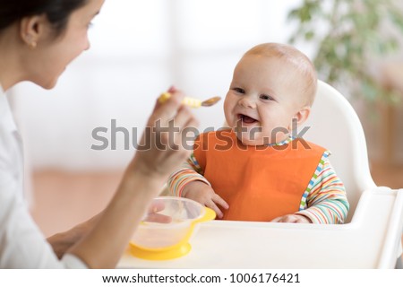 Similar – Image, Stock Photo Mom feeds her little son sitting on a chair in the kitchen