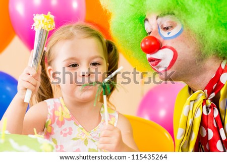 happy child girl playing with clown on birthday party