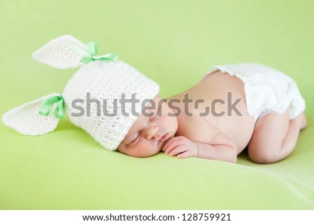 Funny sleeping newborn baby girl over green background