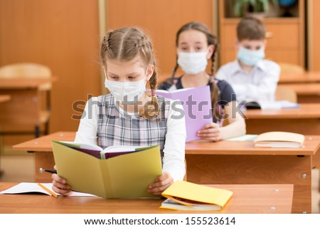 school kids with protection mask against flu virus at lesson