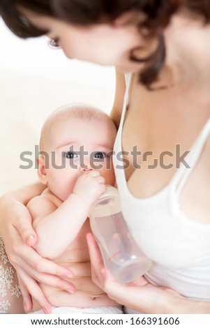 mother feeding  her baby girl from bottle
