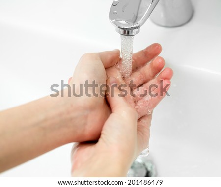 Close-up of hands under stream of water from faucet