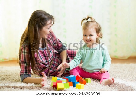 happy mom and kid play toys at home