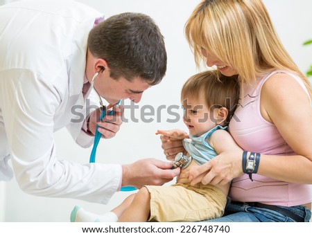 male doctor examining kid boy patient with stethoscope