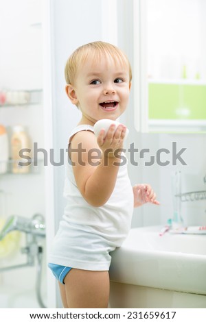 kid boy washing hands with soap in bathroom