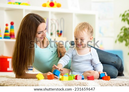 cute mother and her son play together indoor