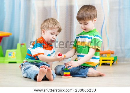 children brothers playing together in nursery at home
