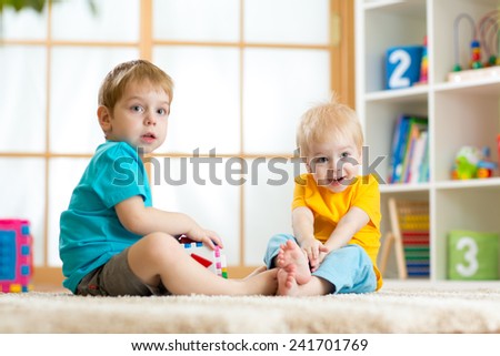 two children boys playing together with educational toys