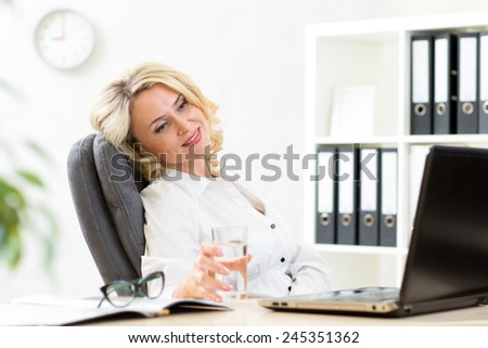 middle-aged businesswoman relaxing at work in office