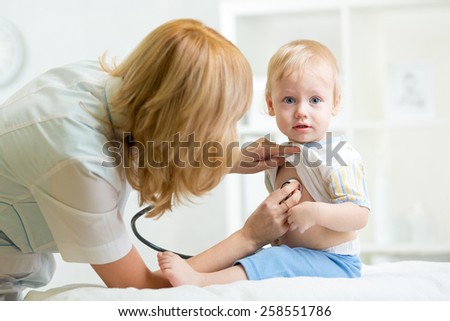 pediatrician examining heartbeat of kid boy with stethoscope