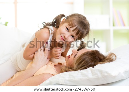 Cute child and her mom have fun pastime in bedroom