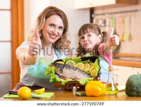 kid daughter and mother showing thumb up cooking in domestic kitchen