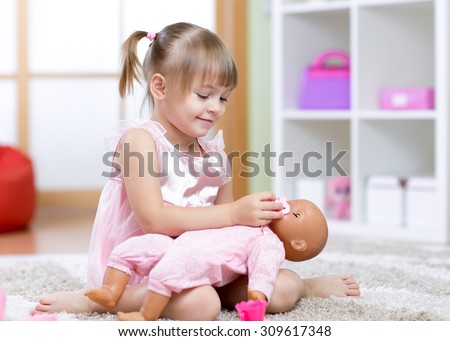 Beautiful child girl playing doctor with a doll