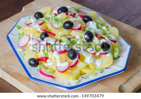 Potato and yogurt salad with black olives and radish