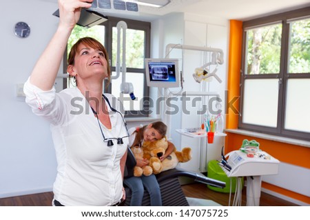 A dentistry doctor looks x-ray picture in a doctor-surgery