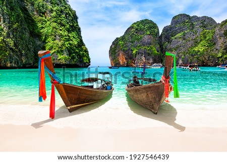 Beautiful beach with thai traditional wooden longtail boat and blue sky in Maya bay, Thailand. Vacation holidays summer background. View of nice tropical beach in Maya bay near Phuket in Thailand.