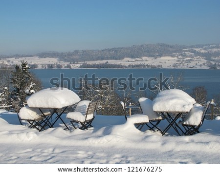 Snow Covered Garden Furniture And Winter Landscape