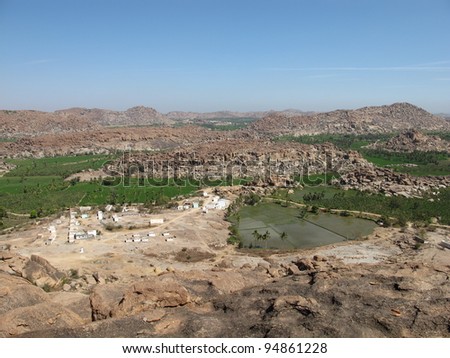 Little village near Hampi, India. Rice fields and granite mountains.