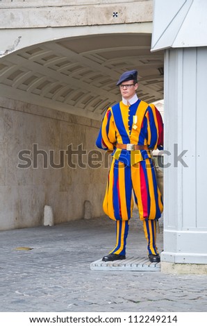 VATICAN CITY, ITALY - MARCH 23: A Papal Swiss Guard stands guard at the entrance of Saint Peter's Basilica on March 23, 2012. Swiss Guards in their traditional uniform.