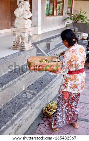 UBUD, INDONESIA-OCT 17: unidentified woman praying god in Ubud, Bali, Indonesia, on 17 October 2013. Every morning women bring flowers and incense to their gods