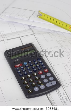 Yellow measuring tape and calculator lying on construction plans