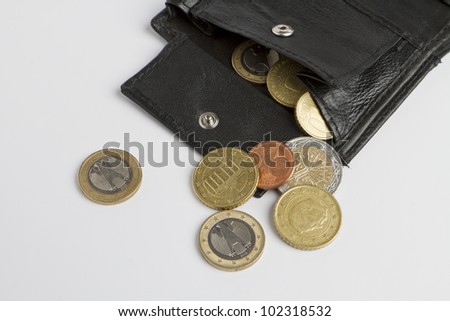 loose cash falling out of black wallet in light grey background