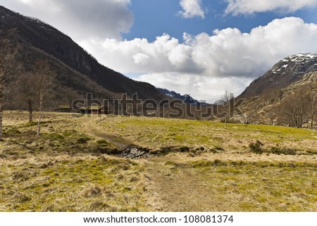 rural landscape with mountains and small building in background. norway