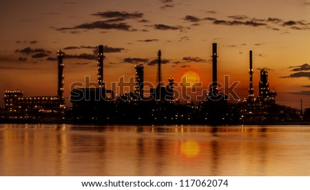 Refinery industrial plant with river and sunset