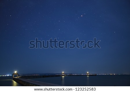 Space on the background with star, sea and wooded bridge.