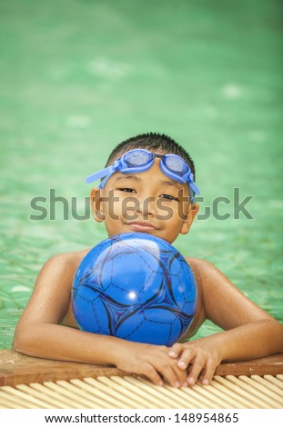 little boy playing in swimming pool under sunset light on the face