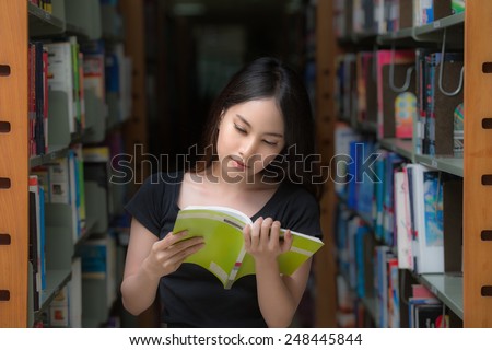 A portrait of a mixed race college asia student at campus in library and read a book