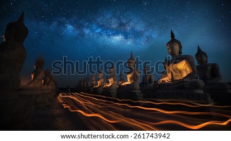 Thai people in Candly festival with Buddha statue and milky way in dark night sky in Thailand