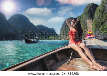 Asian lady relax on long tail boat at maya beach, Phi Phi island near Phuket in Thailand
