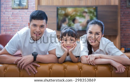 happy young family wathching flat tv at vintage home indoor