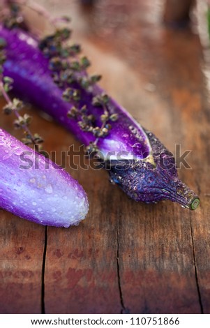 Photo of two Japanese  eggplants with water droplets on a wood table