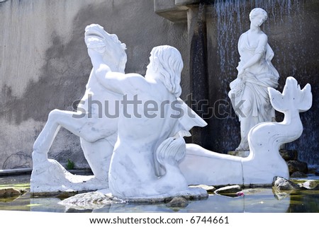 Statue of a greek god washing his horse in a fountain