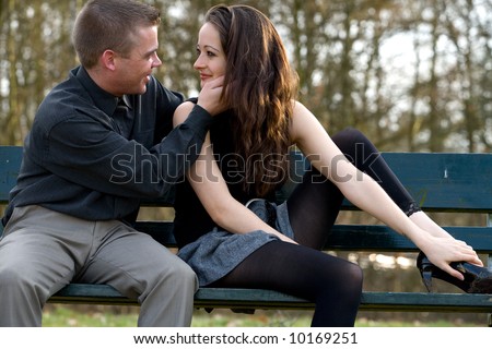 Man and girlfriend on a park bench caring