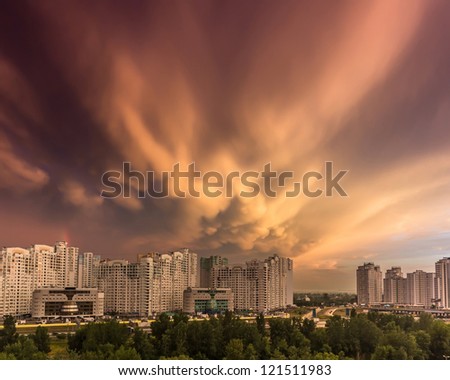 Dramatic colorful stormy sunset clouds over row of typical residential