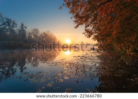 Beautiful misty sunrise river. Fisherman in the boat as small detail.
