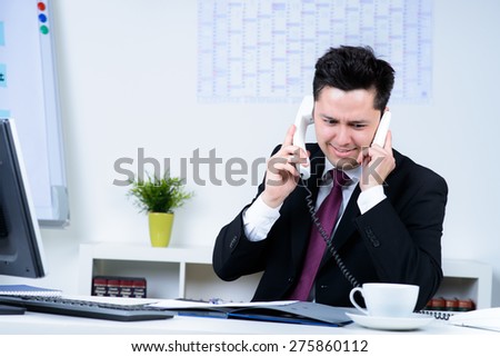 attractive business man overloaded at work in office