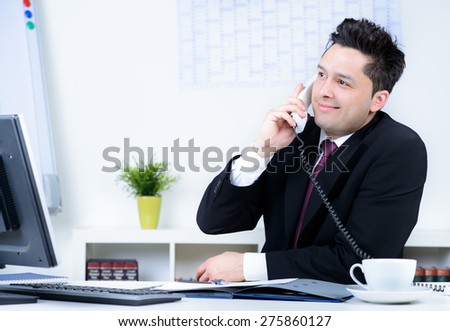 attractive business man in office speaking at telephone