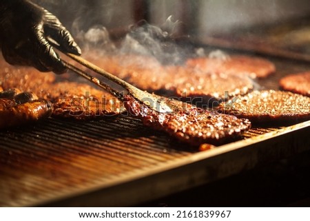 Similar – Image, Stock Photo Chef preparing burgers at grill plate on international urban street food festival.