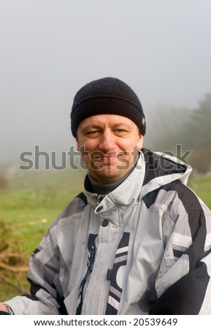 The tourist in a waterproof jacket against a foggy landscape