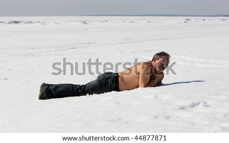The man sunbathes on snow in the winter
