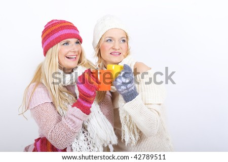 two Young sexy winter woman in knit clothes with cup of hot chocolate in gloves