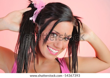 Beautiful happy woman with funny dual pony tails hairstyle. pink background