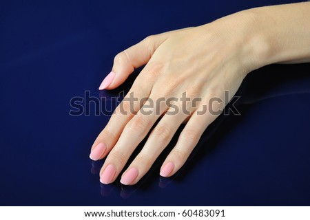 Beautiful hands with perfect nail pink manicure. isolated on blue background